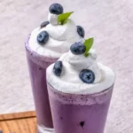 The image features two glasses of Grimace Shake Recipe, each topped with a generous swirl of whipped cream