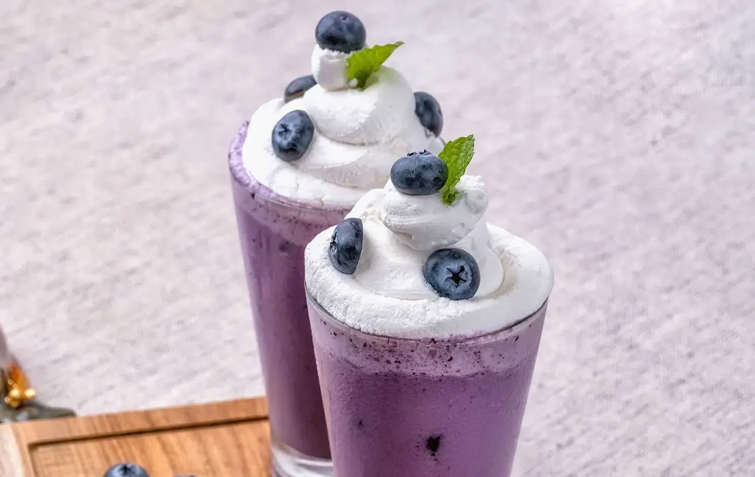 The image features two glasses of Grimace Shake Recipe, each topped with a generous swirl of whipped cream