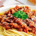 The image features a generous serving of TikTok Spaghetti Recipe pasta topped with a rich and hearty meat sauce.