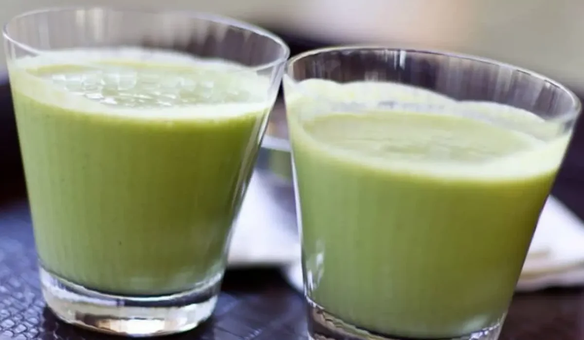 The image displays two glasses of green Herbalife shakes on a dark surface.
