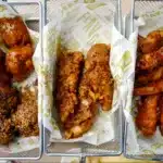 The image shows three varieties of fried chicken presented in baskets lined with branded paper from Wingstop Ranch Recipe