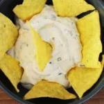 a bowl WingStop Ranch sauce with nachos in it