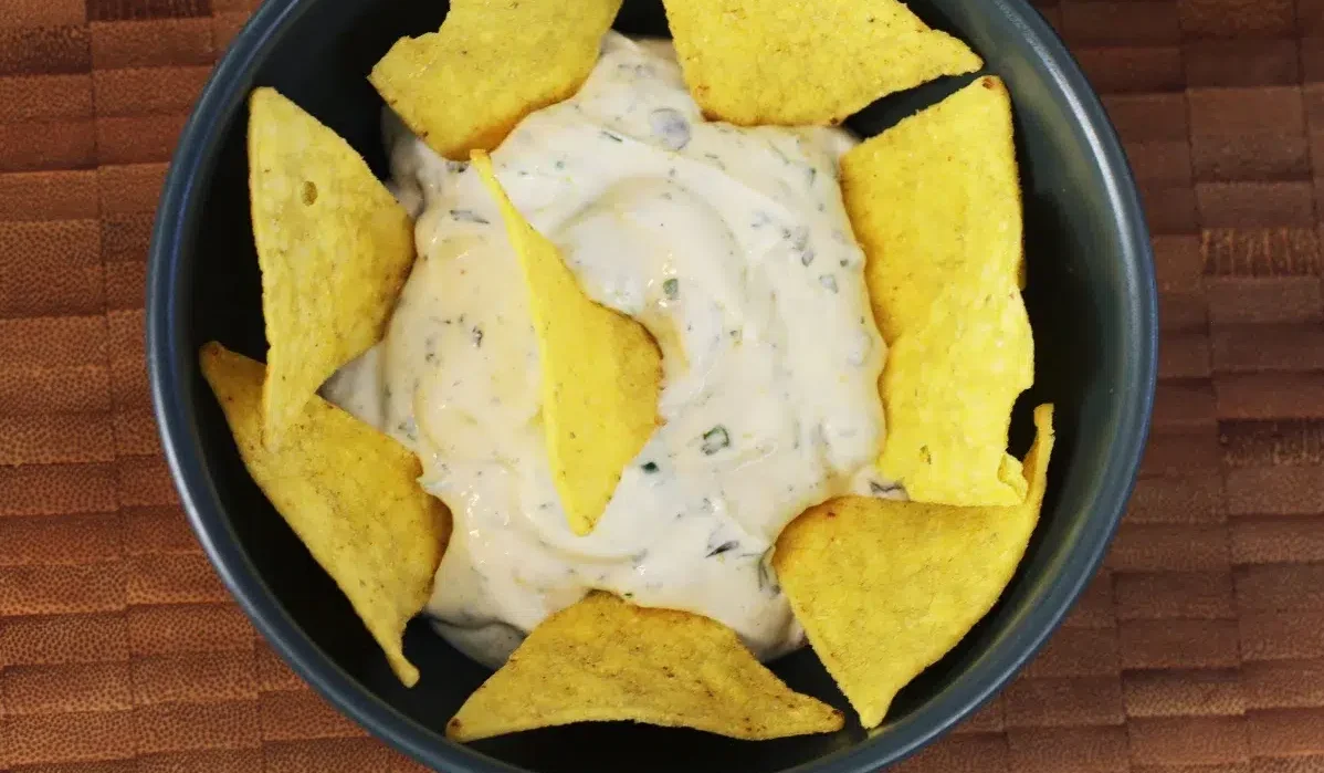 a bowl WingStop Ranch sauce with nachos in it