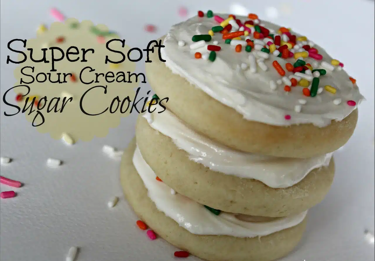 A stack of sugar cookies with sour cream and sprinkles on a white plate.
