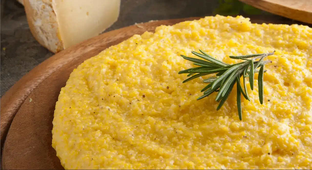 A plate of cornmeal polenta with a sprig of rosemary on top.