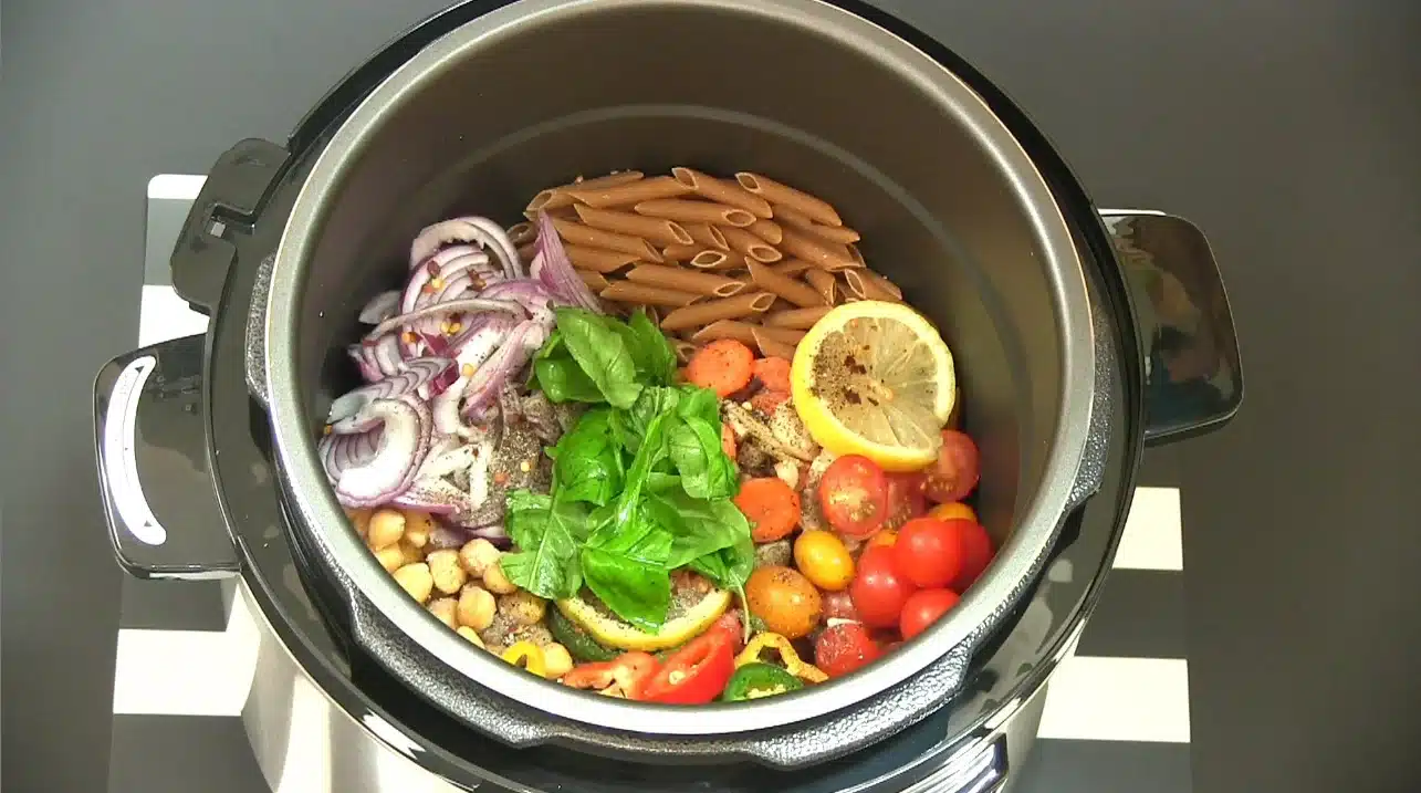 The image shows a variety of raw ingredients inside a Ninja Speedi pressure cooker ready to be cooked.