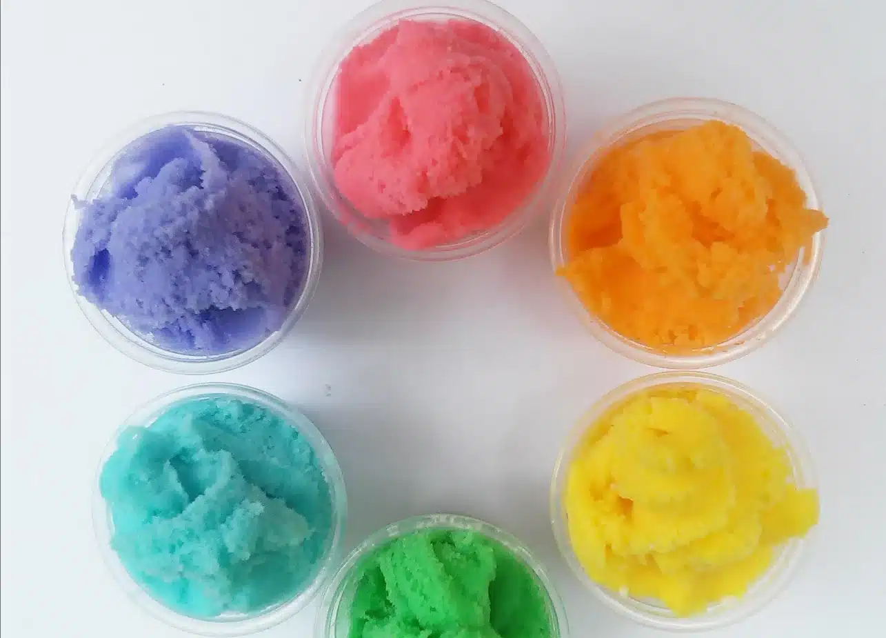 The image shows six small containers, each filled with a different color of cloud slime recipe.