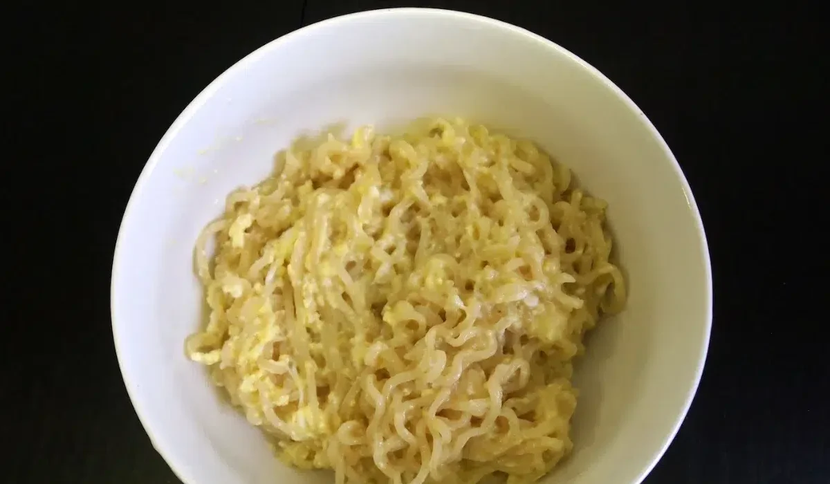 The image displays a white bowl filled with cooked instant ramen Boujee.