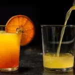 A glass of Corona Sunrise with an orange on top.