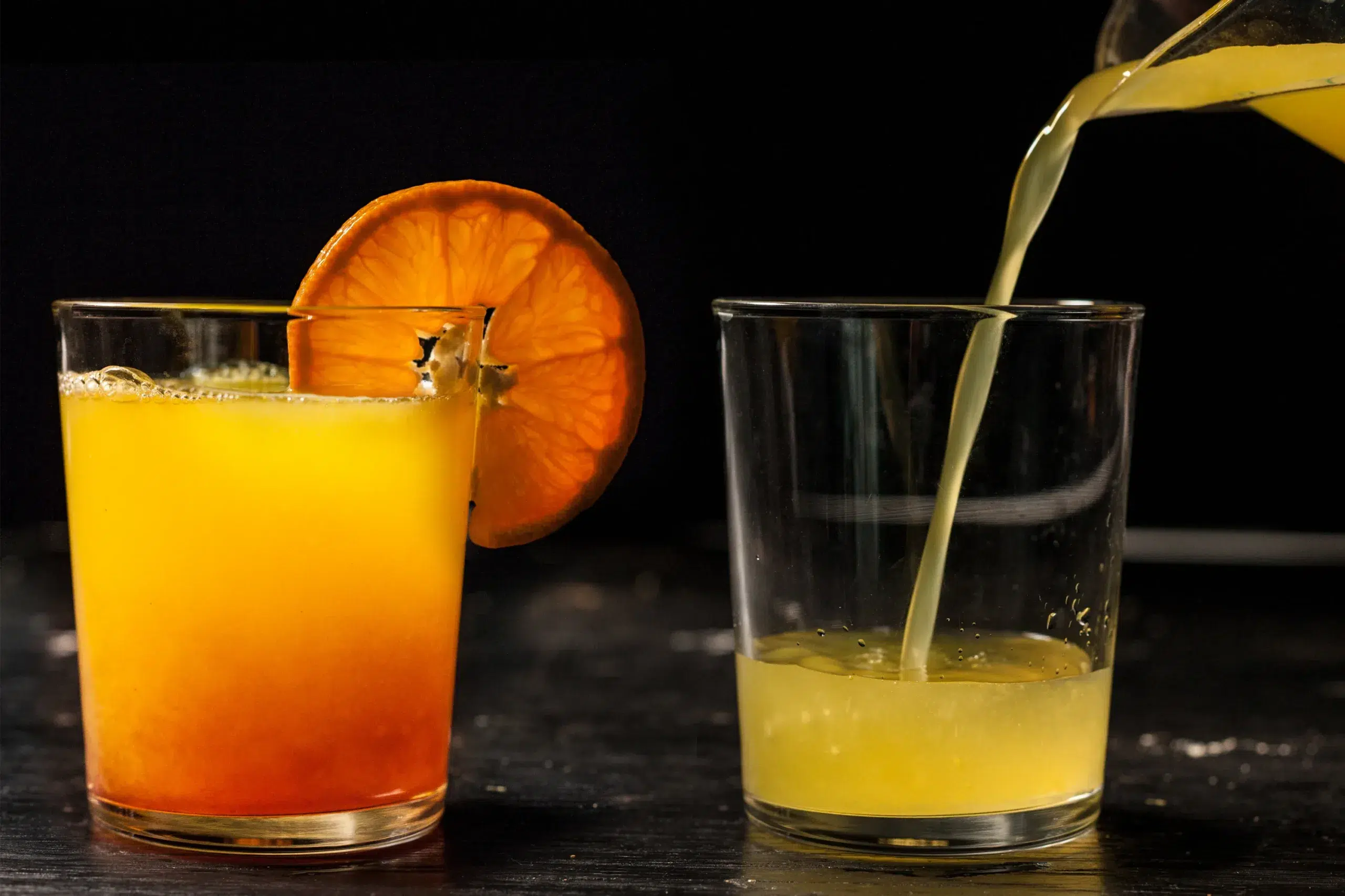 A glass of Corona Sunrise with an orange on top.