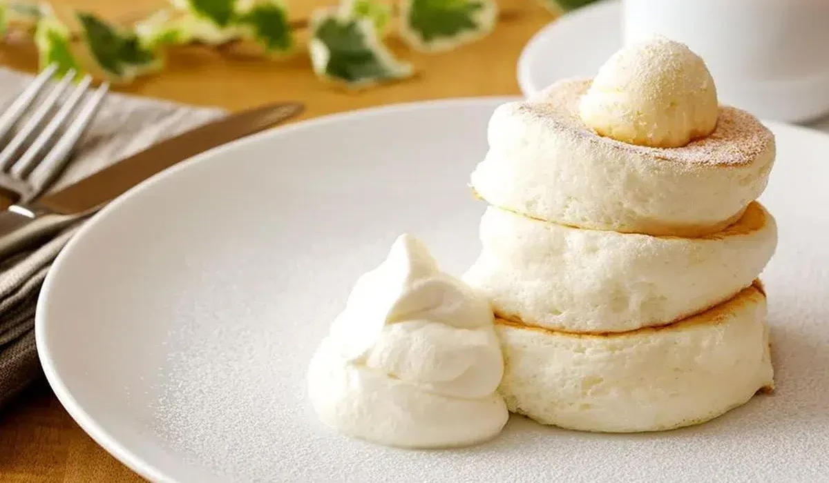 The image features a stack of three Japanese fluffy pancakes on a white plate