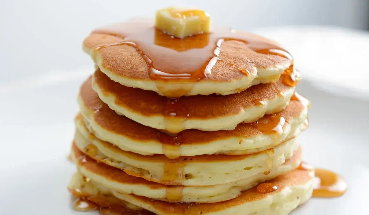 Image of a stack of pancakes with honey and butter milting made by billy parisi recipes