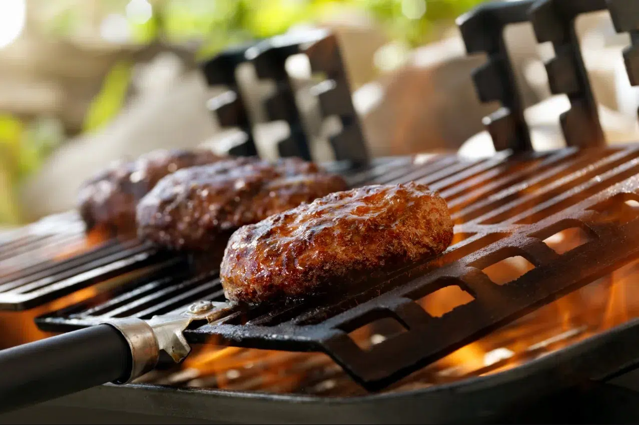 This is an image of hamburgers cooking on a hibachi grill.