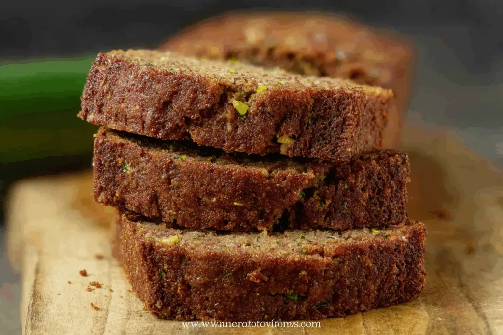 Moist zucchini bread recipe loaf sliced open on wooden table
