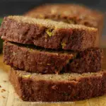 Moist zucchini bread recipe loaf sliced open on wooden table