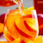 Peach sangria recipe with fresh peaches and mint in a pitcher